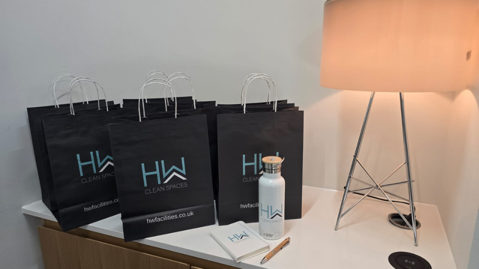 HW branded bags, bottles and notepads laid out on a table for new HW employees