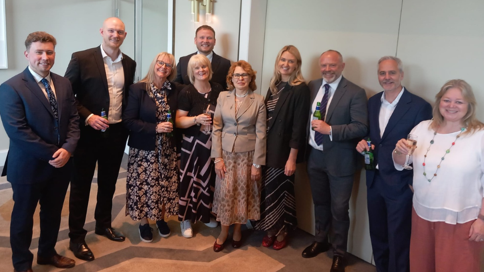 The HW team at the Golden Service awards, standing in a row and smiling at the camera.