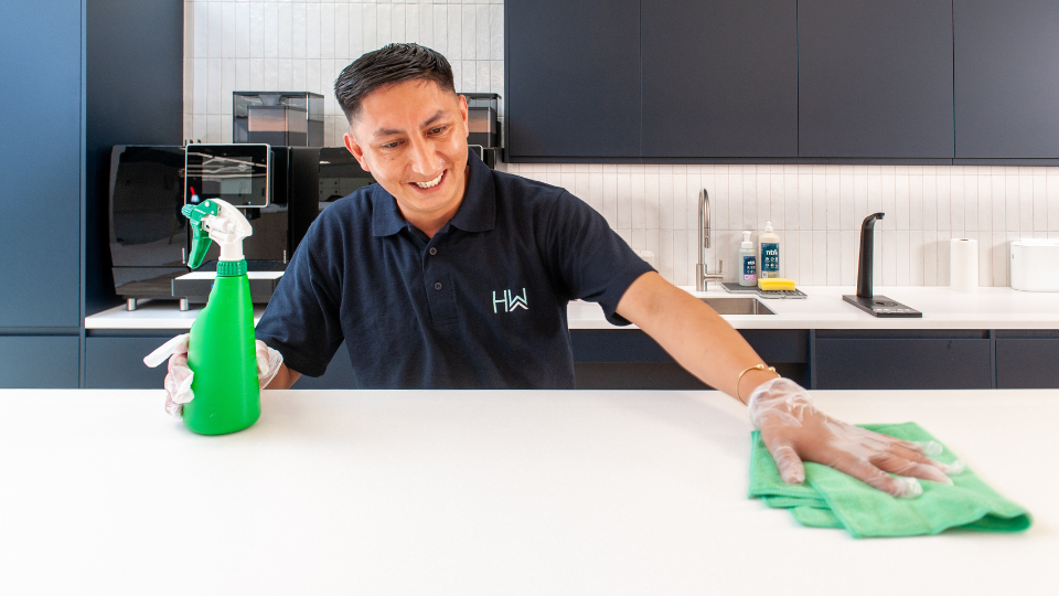 HW Facilities Cleaning Operative using chemical free cleaning in a corporate office, wiping kitchen island