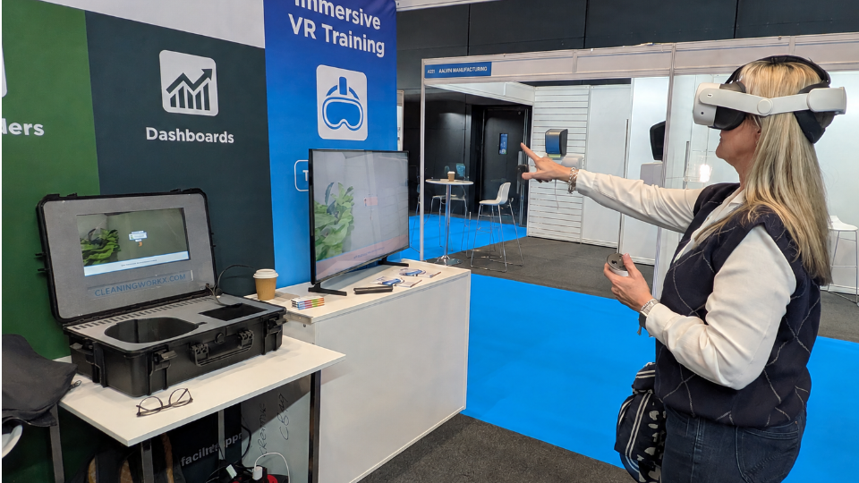 Head of Key Accounts, Zoe Elliott, trying a virtual reality training tool, pointing at the screen while wearing a headset
